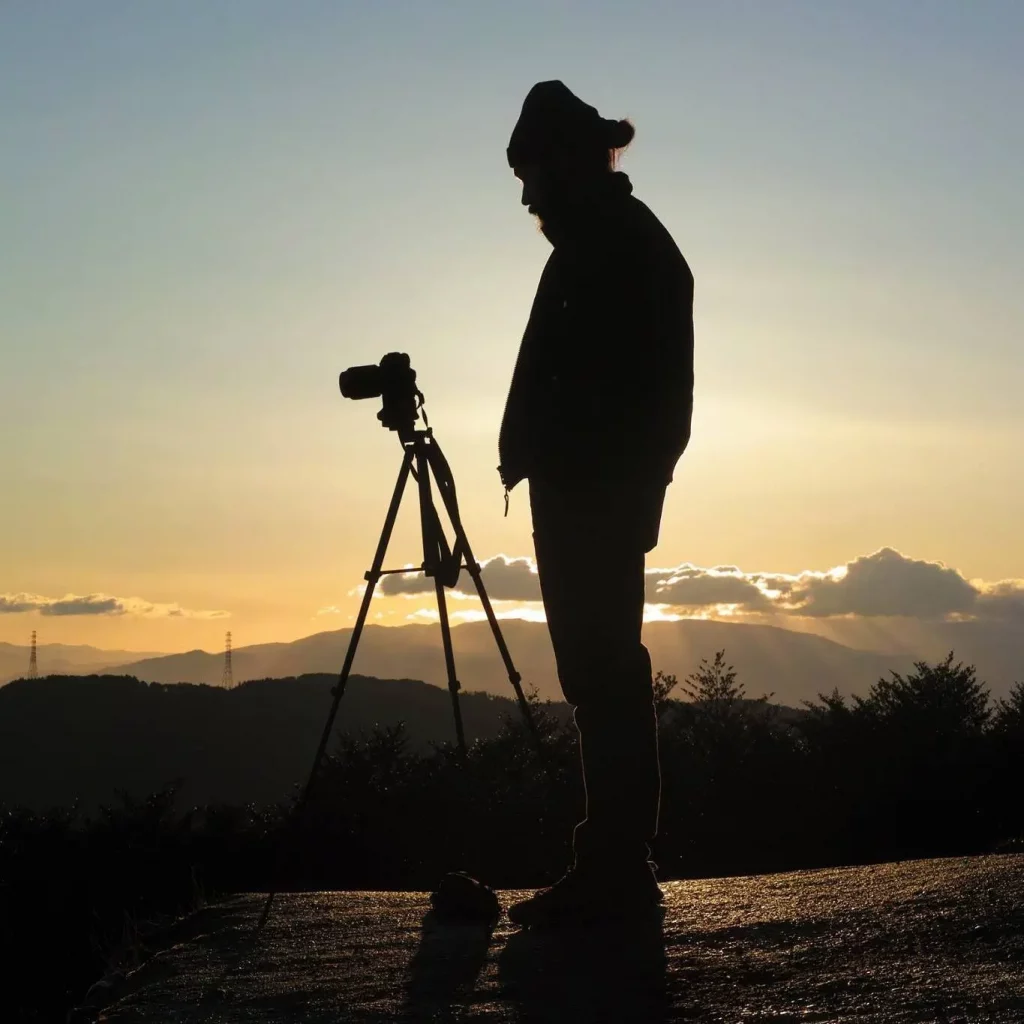 Le photographe Jyazu debout devant son appareil photo Sony sur trépied prenant une photo du Mont Fuji au lever du soleil dans la province de Shizuoka